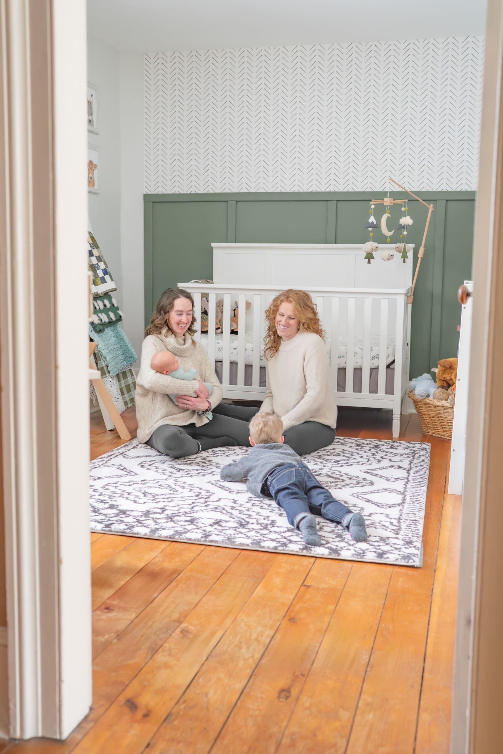 Family sitting in nursery during newborn session — photographed by Alliston and Barrie maternity, newborn, and family photographer.