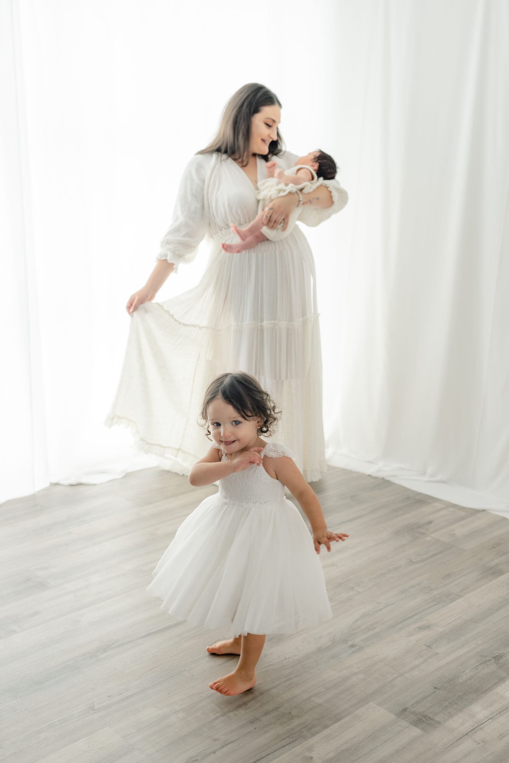 Alliston newborn photographer captures parents and siblings in bright studio setting

