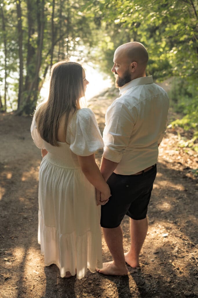 Couple holding hands and looking at each other during family photography session in Barrie